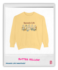 Garment-dyed butter yellow sweatshirt with the Spoonie Life graphic showing cartoon spoons representing daily chronic illness struggles.