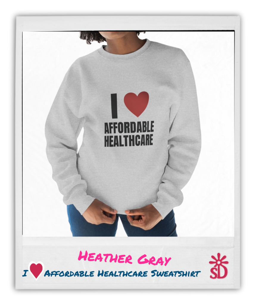 Person wearing a light gray sweatshirt printed with "I [heart] Affordable Healthcare" in bold black lettering and a red heart graphic, shown from shoulders down against a bright background.